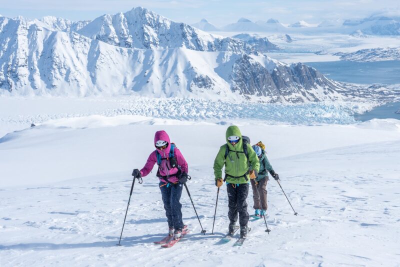 Ski touring in the backcountry of Svalbard while crossing glaciers and mountain ridges covered in snow.