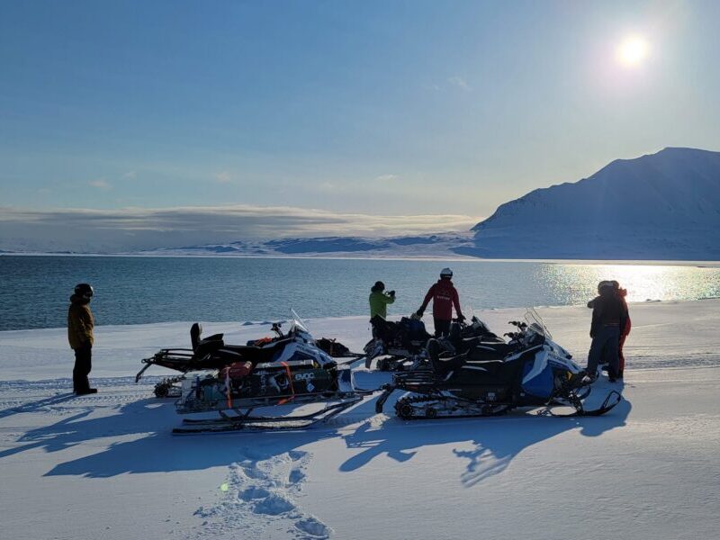 Skiers starting their ski crossing expedition with a snowmobile ride to their starting point