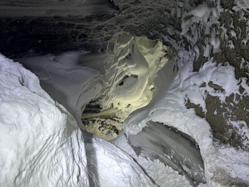 Hiking to a magical ice cave exploring in small groups with an expert guide from Backyard Svalbard