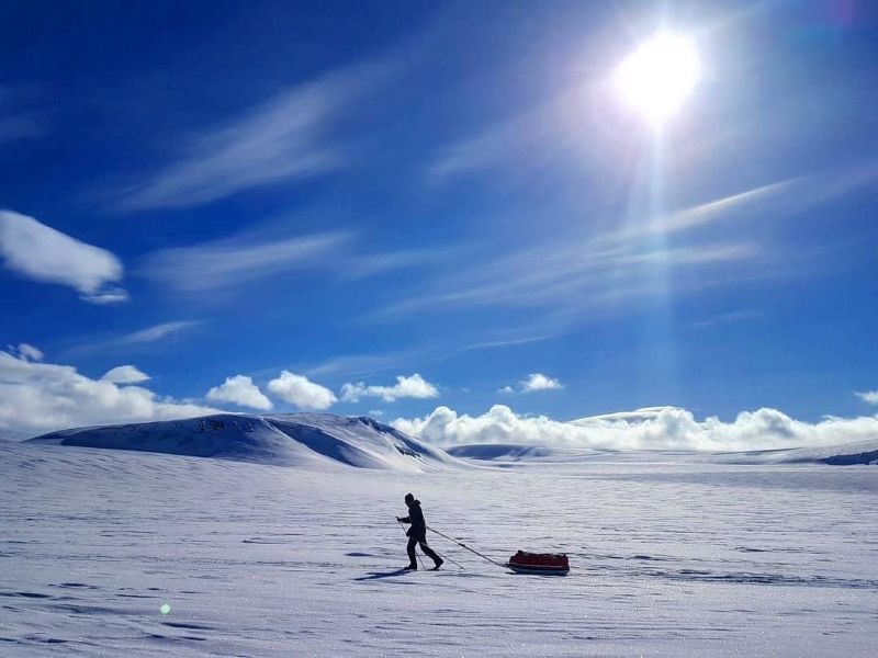 Skiier pulling a pulk from the East coast to West coast on Svalbard ski crossing expedition.