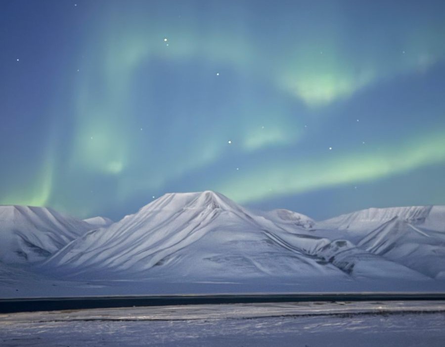 Northern lights over the snowcovered mountains on Svalbard in adventvalley