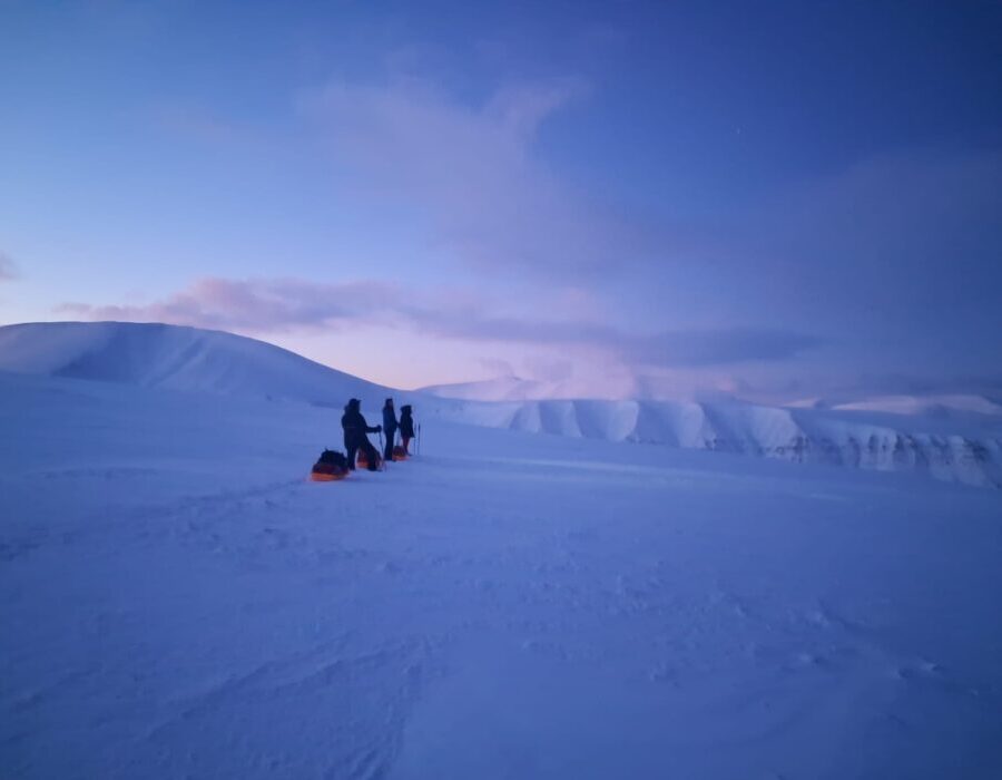 Pulling a pulk (sled) over the snowcovered Svalbard landscape on our wilderness camp tour